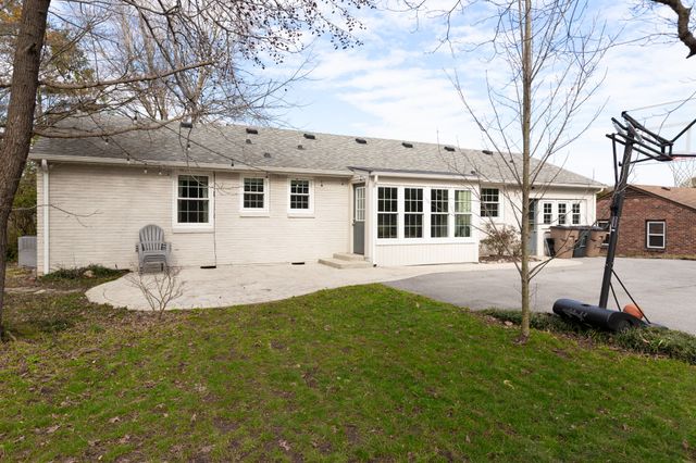 a view of a house with a yard patio and fire pit
