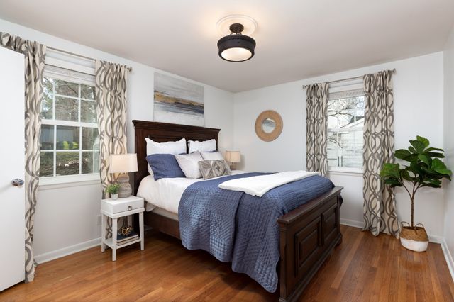 a bed sitting in a bedroom next to a window