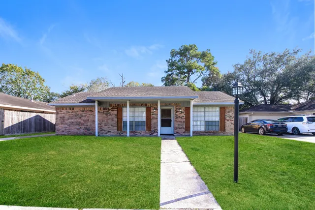 a view of a house with a yard and porch