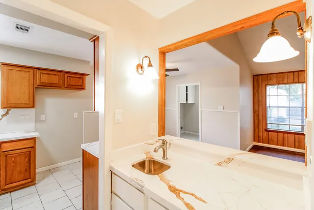 a bathroom with a granite countertop sink and a mirror