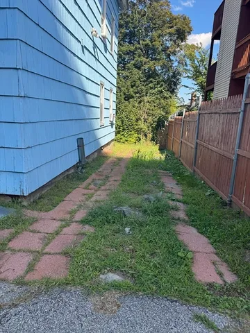 a view of a backyard with wooden fence