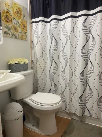 a white toilet sitting next to a shower curtain