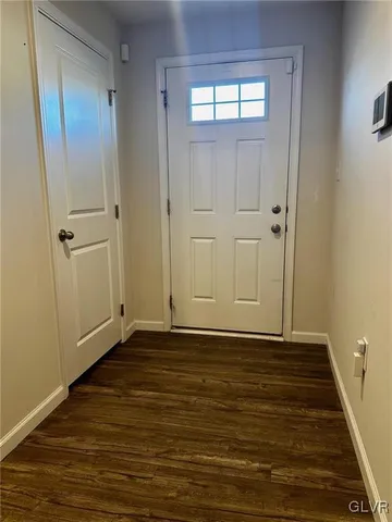 a view of an empty room with wooden floor and closet