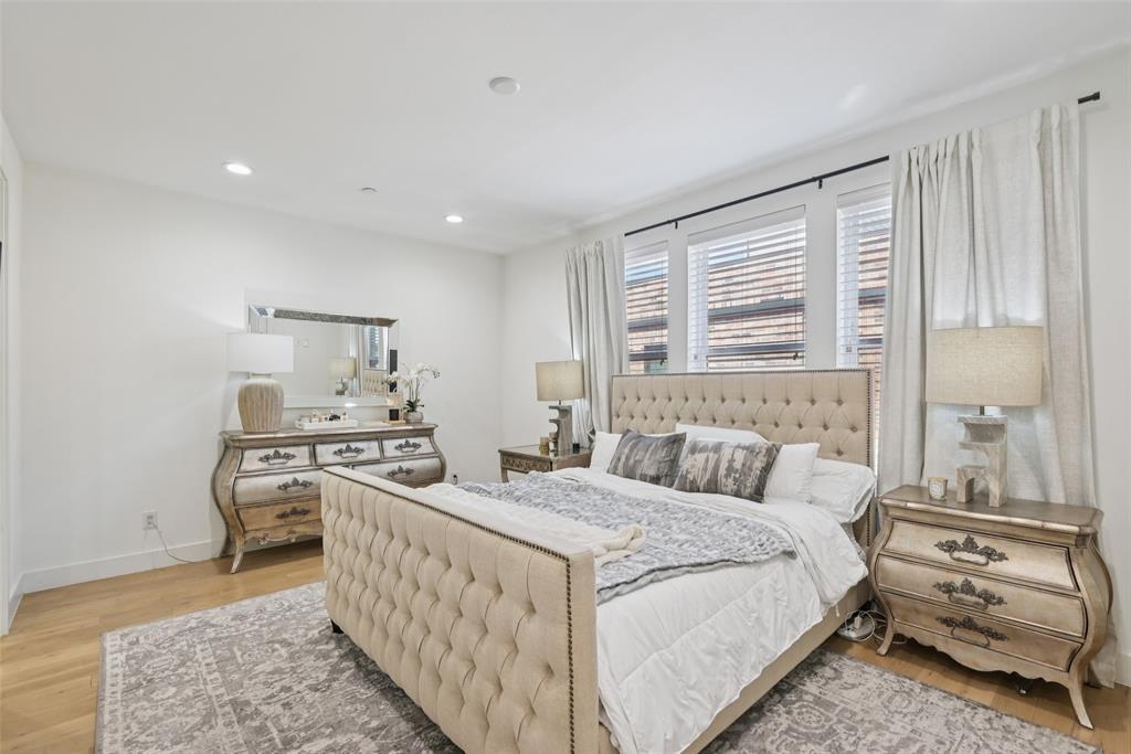 4511 Arberry Lane Dallas, TX 75219 - Photo 13 of 40 Primary bedroom with wood floors and huge windows — no dark, carpeted box here.