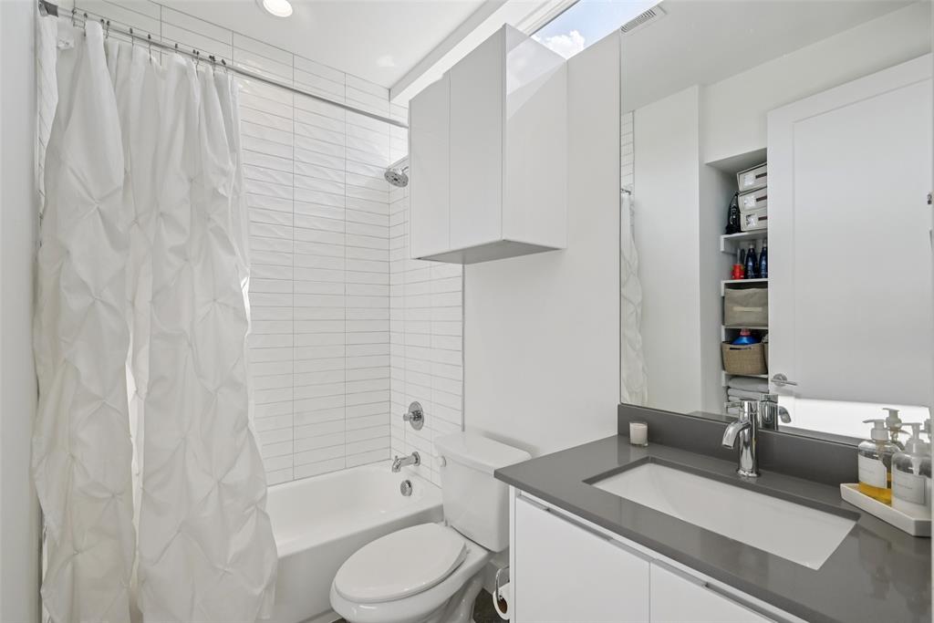 4511 Arberry Lane Dallas, TX 75219 - Photo 20 of 40 Full bath with modern vanity and stylish tile surround.