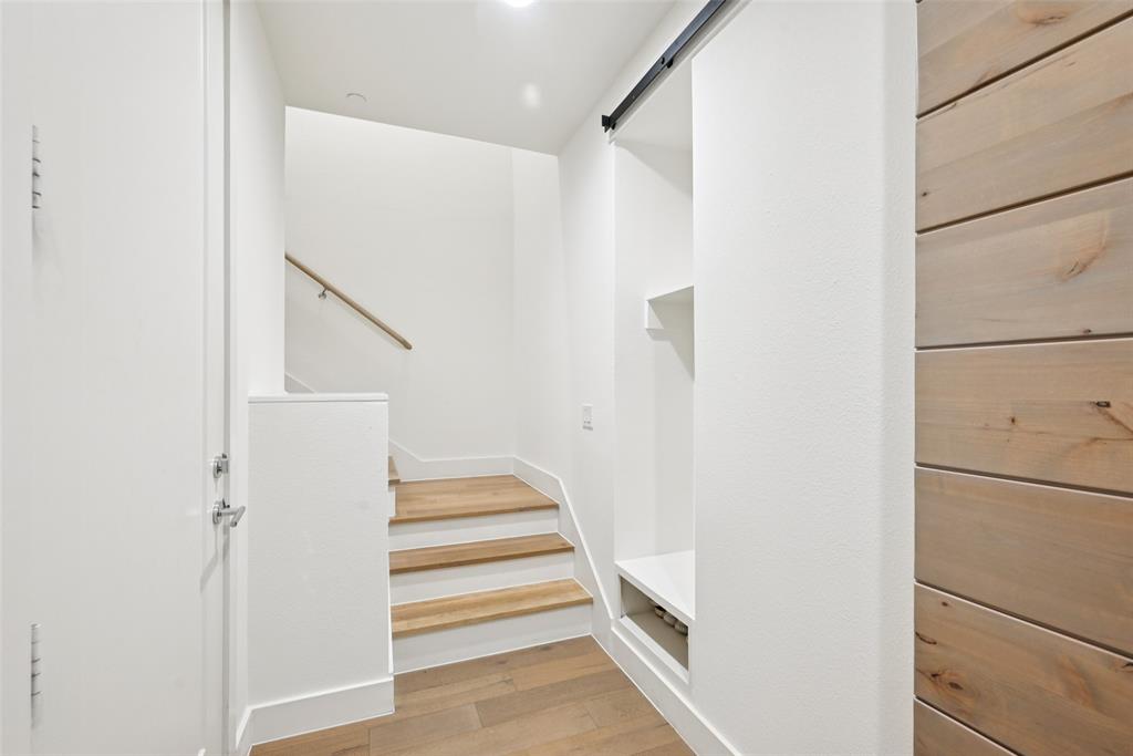4511 Arberry Lane Dallas, TX 75219 - Photo 21 of 40 Modern stairway landing with wood floors and clean lines.