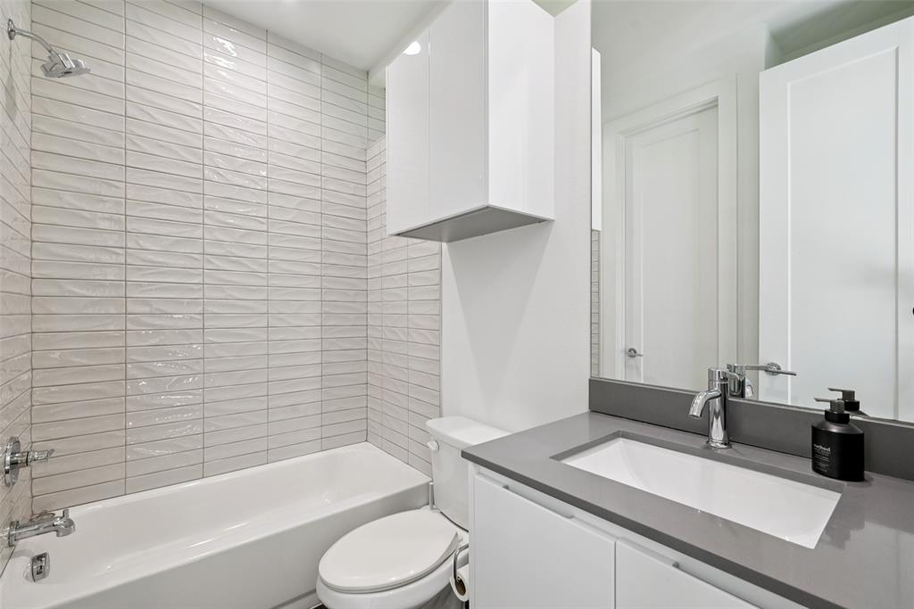 4511 Arberry Lane Dallas, TX 75219 - Photo 26 of 40 First-floor full bath with sleek vanity and tile surround.