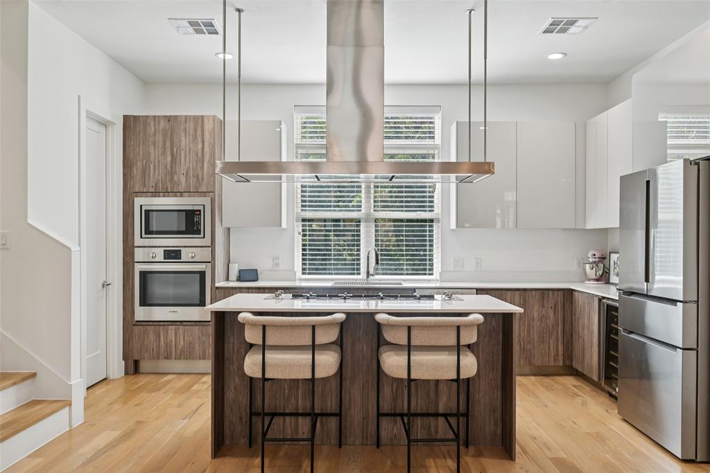 4511 Arberry Lane Dallas, TX 75219 - Photo 7 of 40 Chef’s kitchen with massive island, gas cooktop, and statement vent hood.