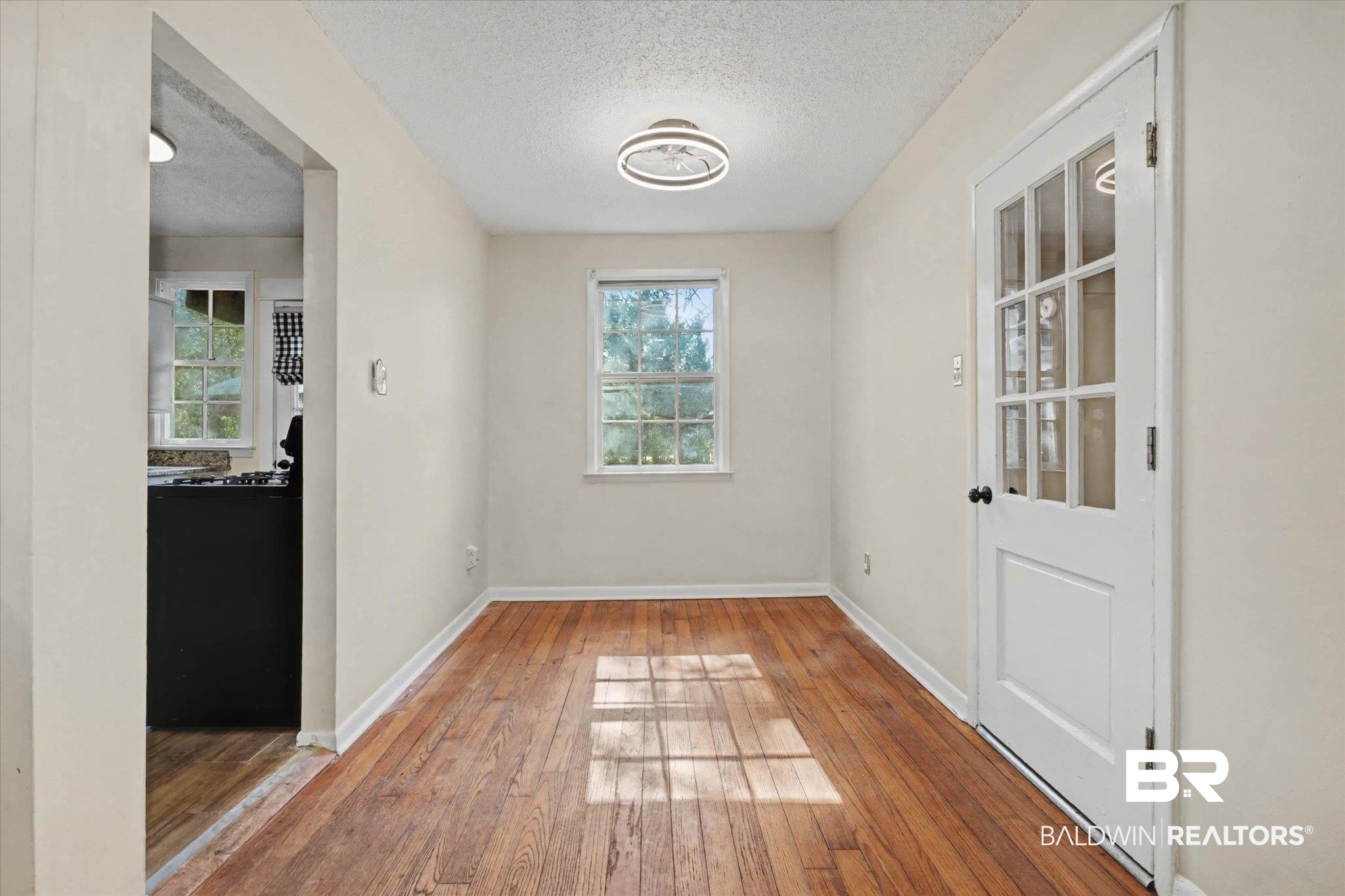 5117 Norton Lane Mobile, AL 36608 - Photo 7 of 35 Unfurnished dining area featuring hardwood / wood-style flooring, a textured ceiling, and plenty of natural light