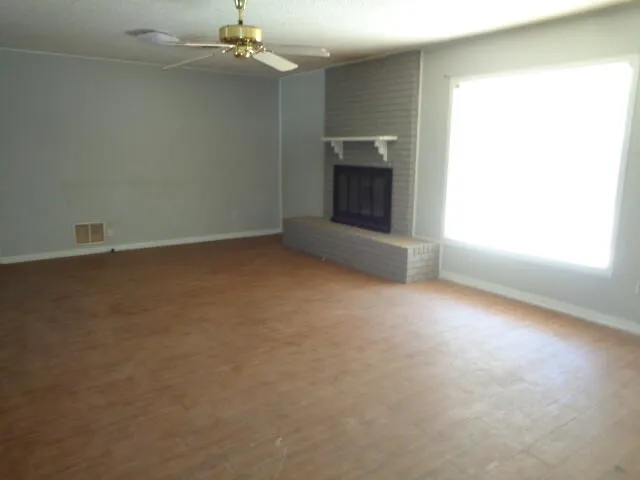 an empty room with windows and fireplace
