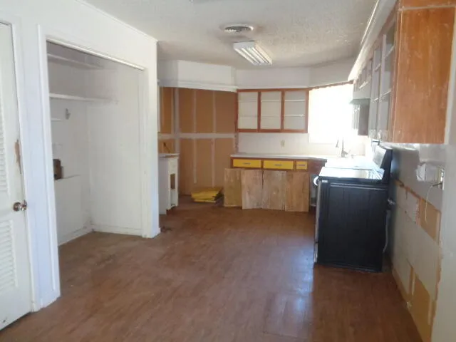 a kitchen with granite countertop a sink stove and cabinets