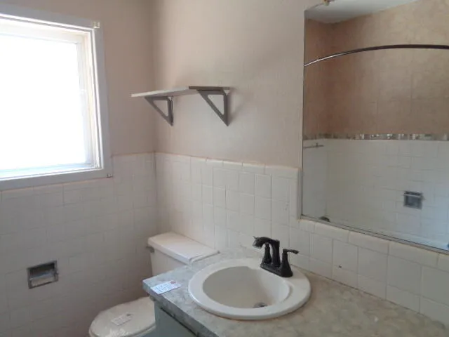 a bathroom with a sink a mirror and a toilet