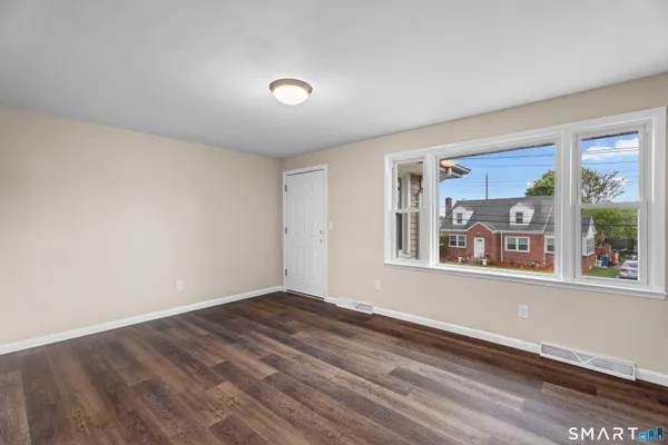 a view of a room with wooden floor and window