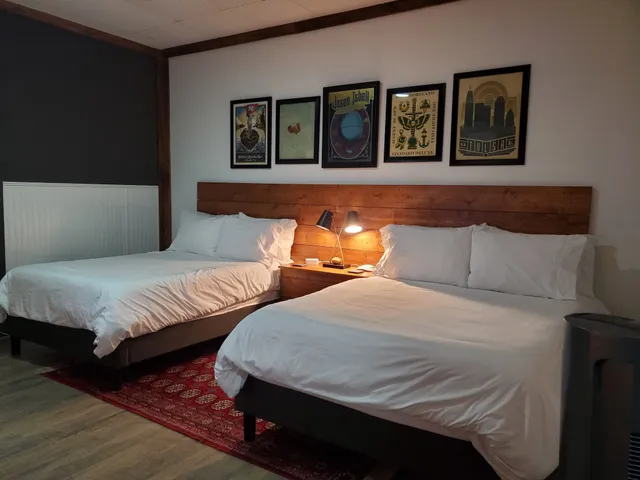 a bedroom with two beds and painting on the wall