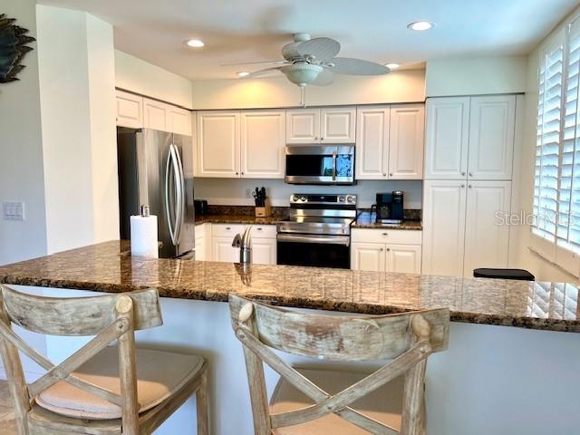 2060 Matecumbe Key Road, Unit 2301 Punta Gorda, FL 33955 - Photo 8 of 41 a kitchen with stainless steel appliances granite countertop a stove top oven a refrigerator a sink and a dining table with white cabinets