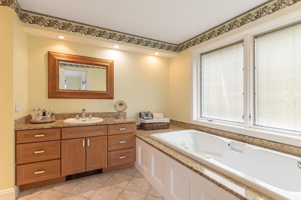 79 Clark Road Ipswich, MA 01938 - Photo 27 of 35 a bathroom with a granite countertop sink mirror and a bathtub