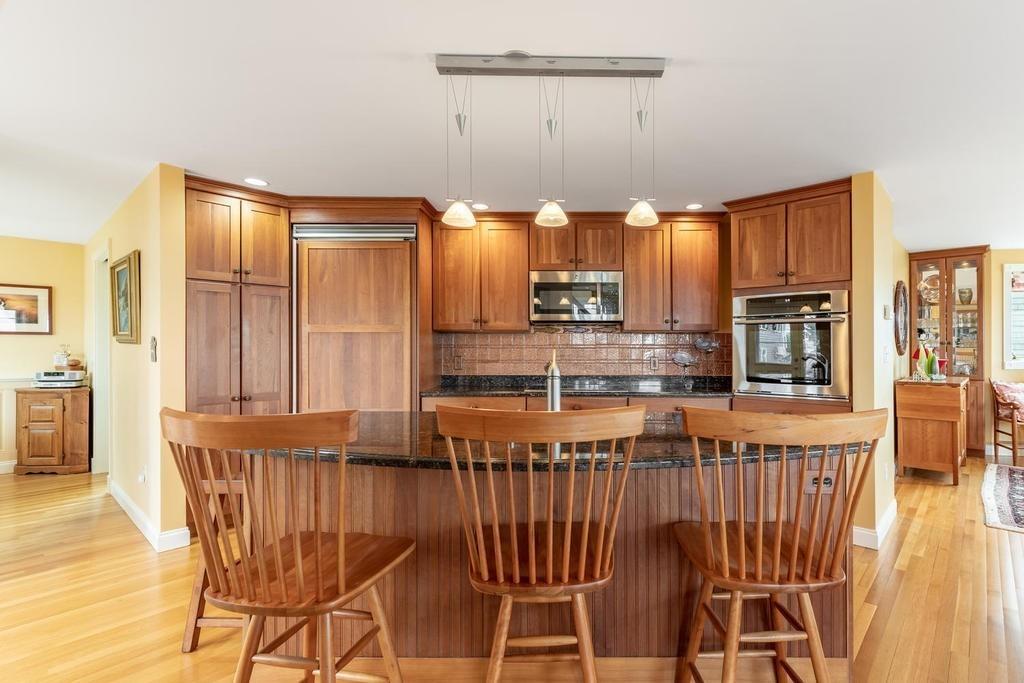 79 Clark Road Ipswich, MA 01938 - Photo 7 of 35 a kitchen with stainless steel appliances wooden floor dining table and chairs