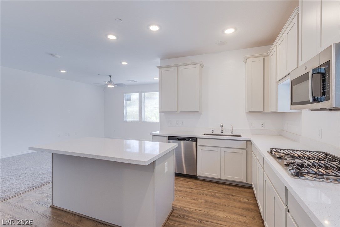 2555 Hampton Road, Unit 8206 Henderson, NV 89052 - Photo 8 of 25 A pristine kitchen features a large island and ample counter space, seamlessly connecting to an inviting living area.