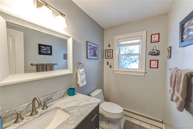 a bathroom with a granite countertop sink mirror vanity and toilet