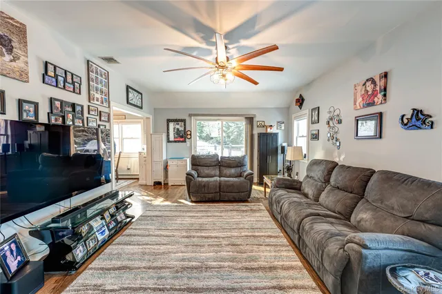 a living room with furniture a flat screen tv and a couch