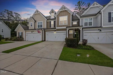 a front view of a house with a garden and trees