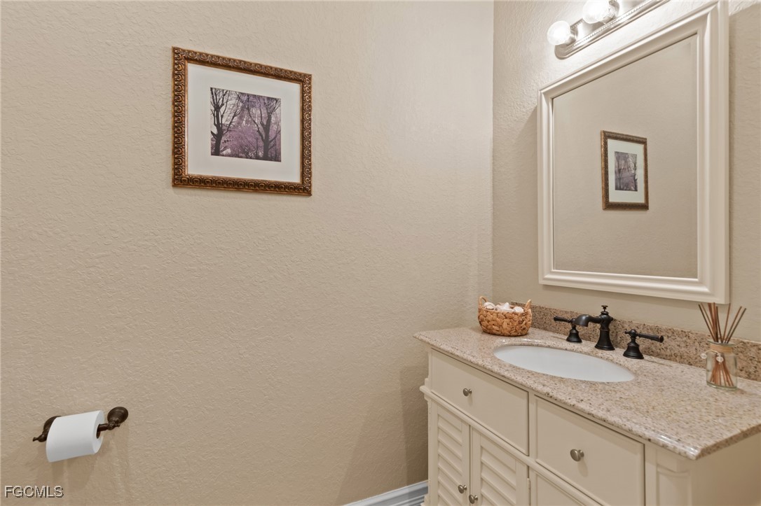 6057 Calusa Rdg Trail Bokeelia, FL 33922 - Photo 14 of 45 a bathroom with a granite countertop sink and a mirror