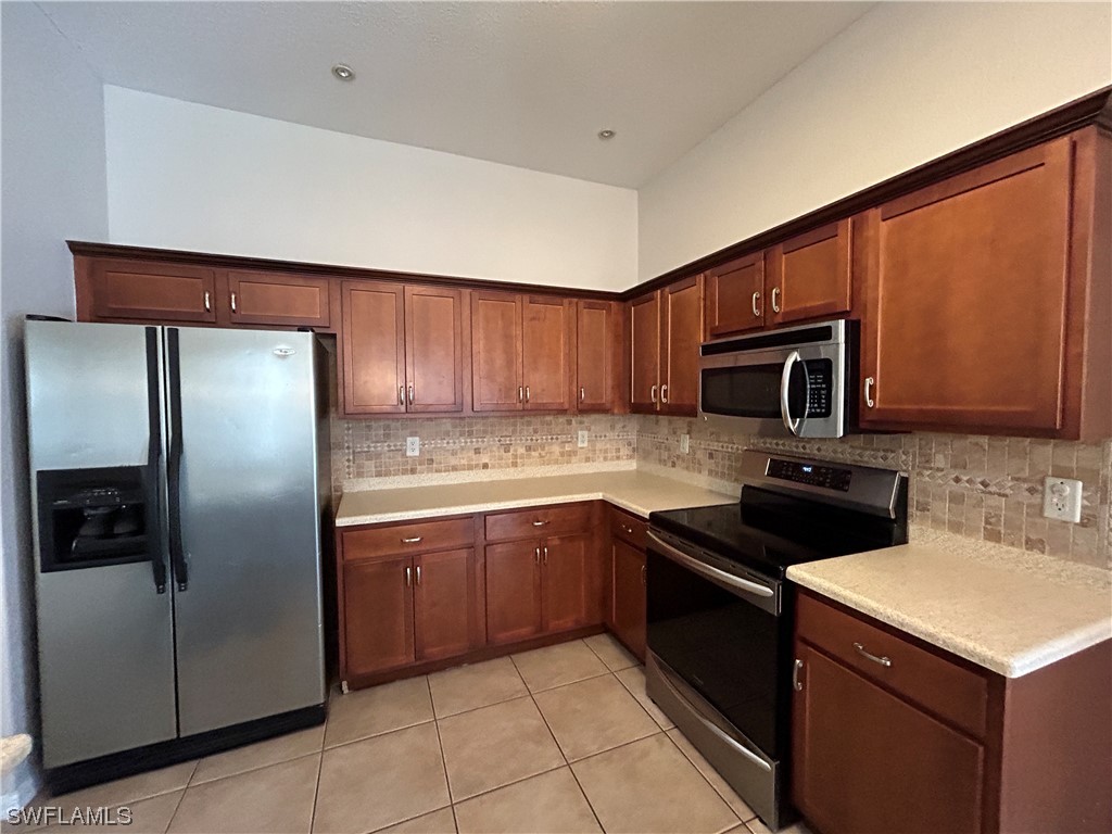 2562 Nature Pointe Loop Fort Myers, FL 33905 - Photo 21 of 44 a kitchen with stainless steel appliances granite countertop a sink stove and refrigerator