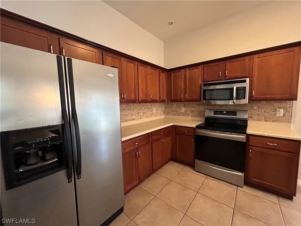 2562 Nature Pointe Loop Fort Myers, FL 33905 - Photo 22 of 44 a kitchen with granite countertop a refrigerator and a stove top oven