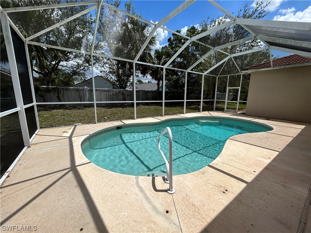 2562 Nature Pointe Loop Fort Myers, FL 33905 - Photo 4 of 44 a view of a swimming pool with a yard and wooden fence