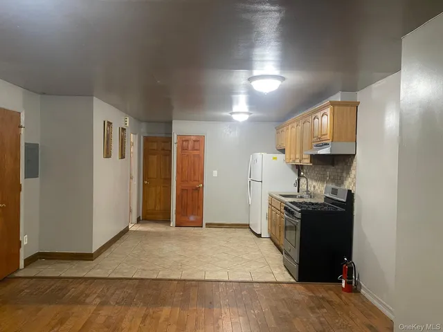 a kitchen with granite countertop a refrigerator stove and sink