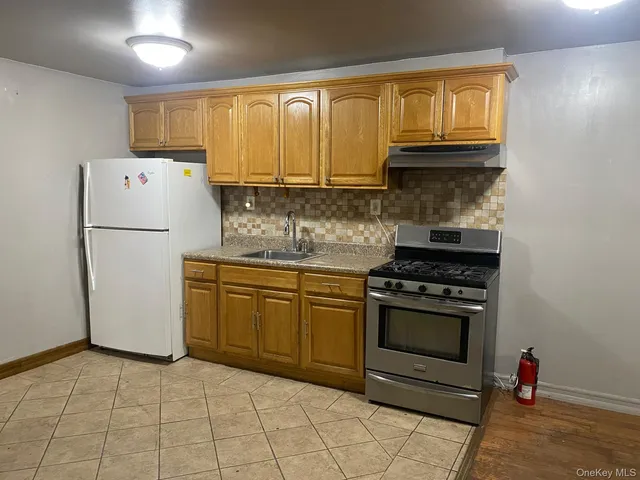 a kitchen with a refrigerator sink and cabinets