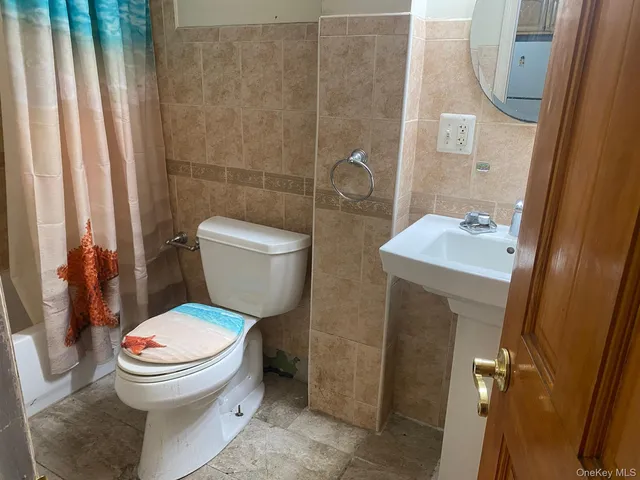 a white toilet sitting next to a bathroom sink and a shower