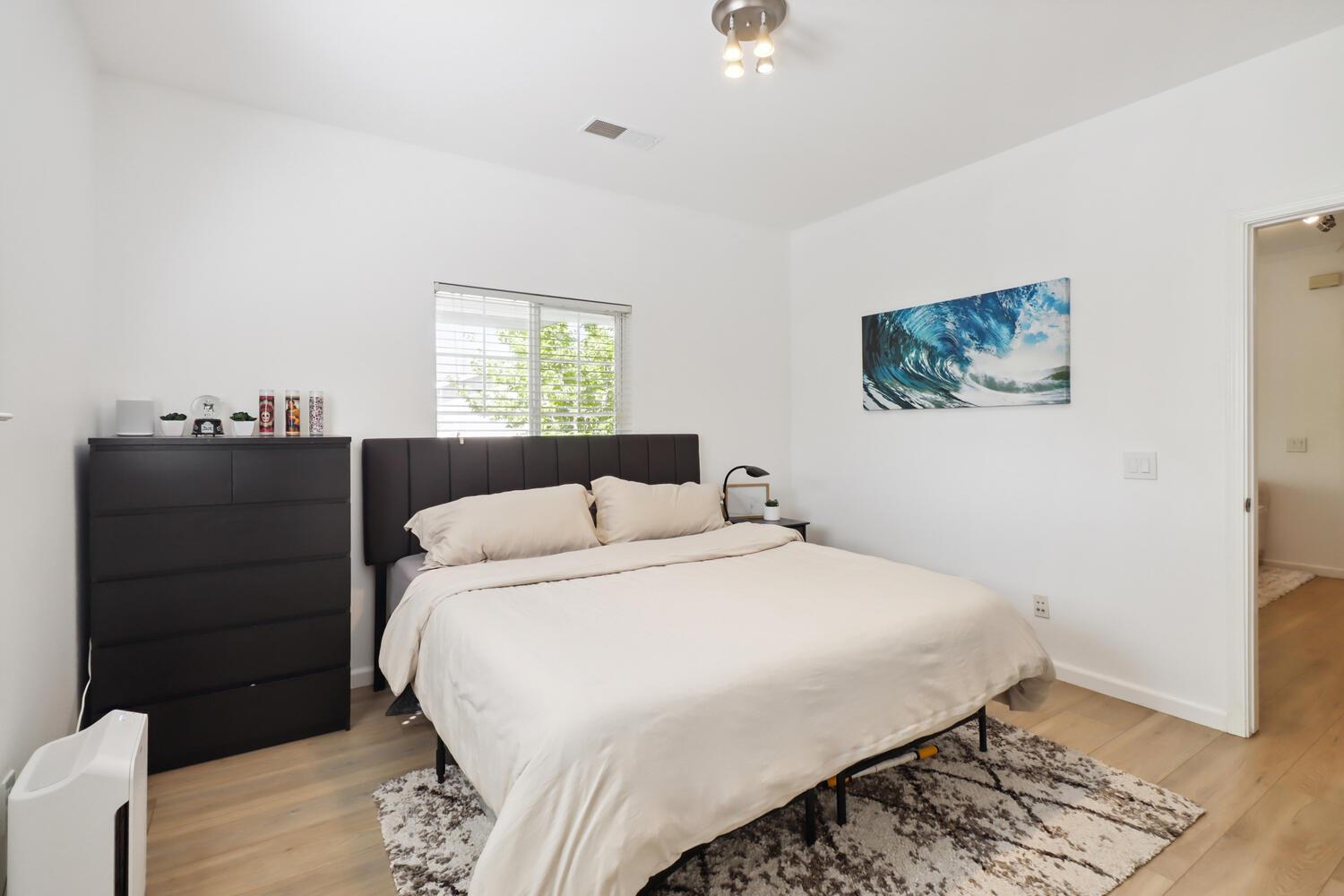 1818 Moore Boulevard, Unit 201 Davis, CA 95618 - Photo 15 of 40 a bedroom with a bed and a painting on the wall