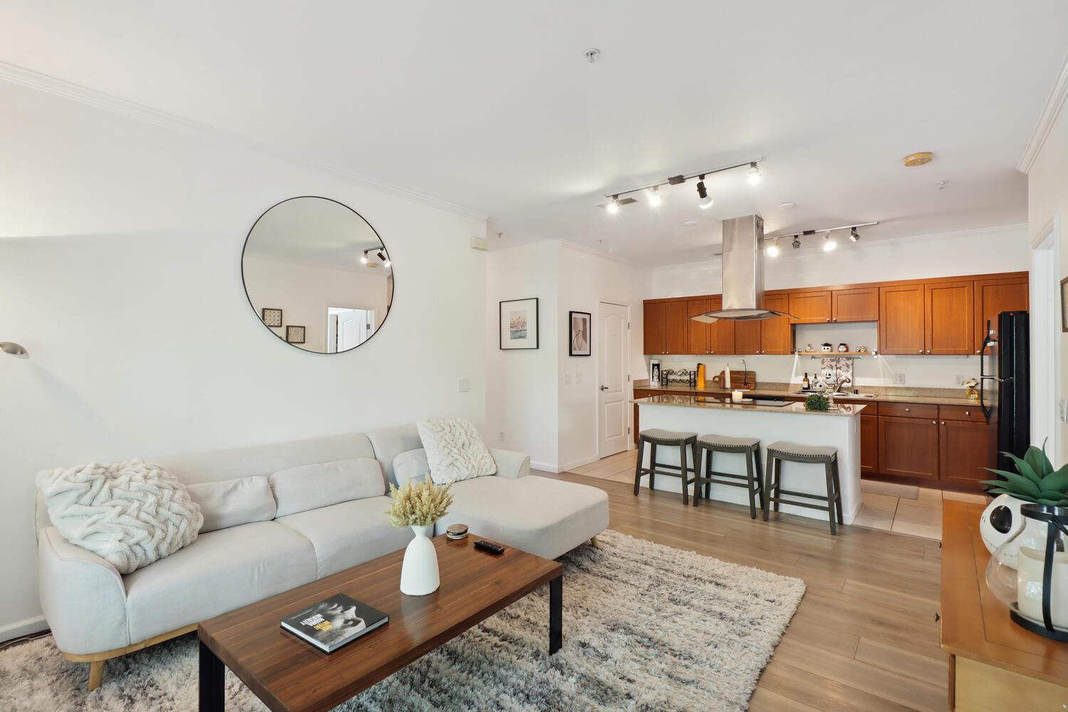 1818 Moore Boulevard, Unit 201 Davis, CA 95618 - Photo 5 of 40 a living room with furniture a rug kitchen view and a chandelier
