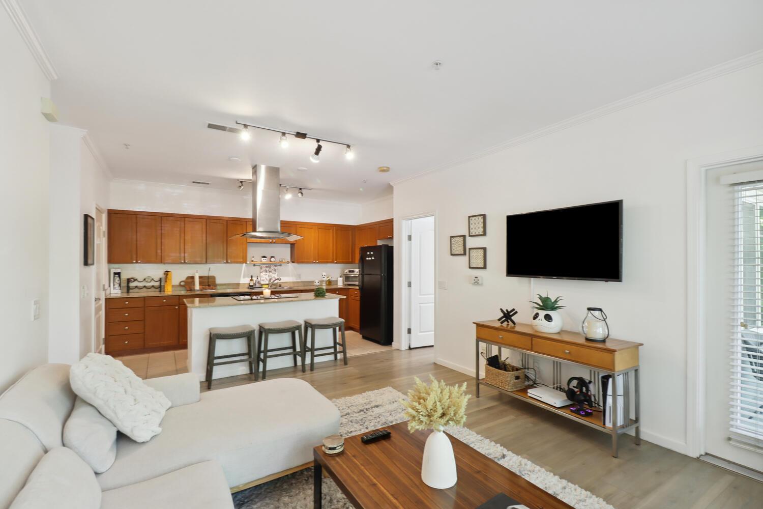1818 Moore Boulevard, Unit 201 Davis, CA 95618 - Photo 6 of 40 a living room with furniture and a flat screen tv