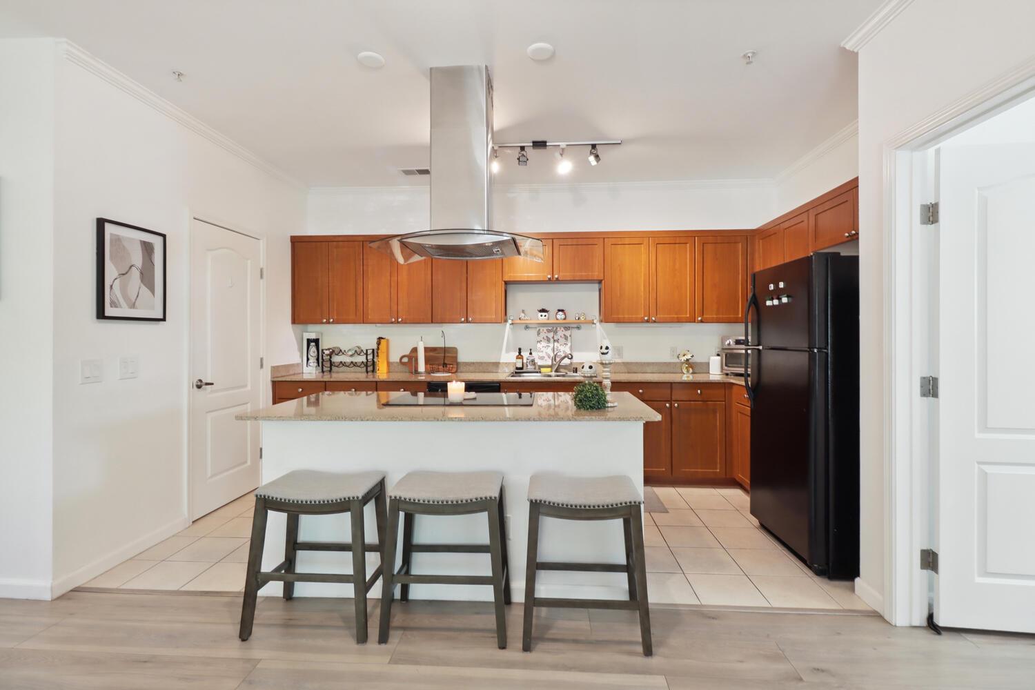 1818 Moore Boulevard, Unit 201 Davis, CA 95618 - Photo 7 of 40 a kitchen with stainless steel appliances granite countertop a refrigerator a sink a stove a dining table and chairs