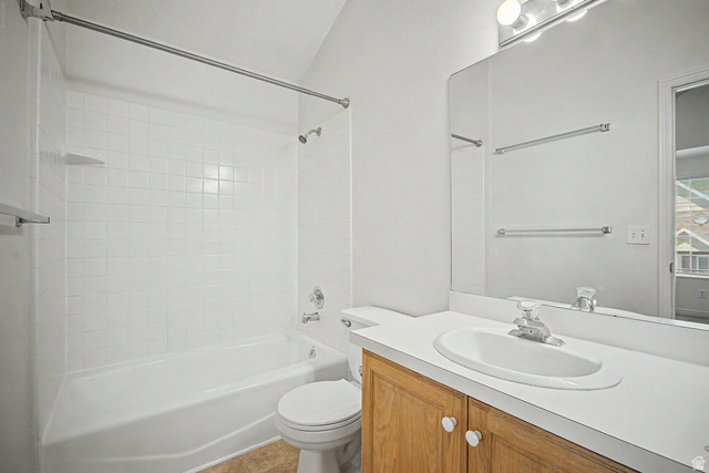 2058 California Avenue, Unit 2 Provo, UT 84606 - Photo 27 of 32 Full bathroom featuring a white tile shower surround, a white bathtub, and a light wood-finish vanity with a white countertop and integrated sink