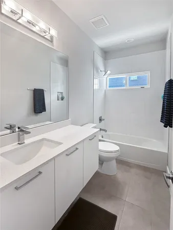 a bathroom with a toilet a sink a mirror and a bathtub