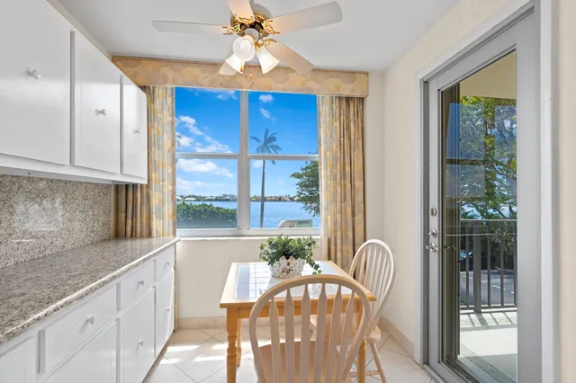 a view of a dining room with furniture a chandelier and large window
