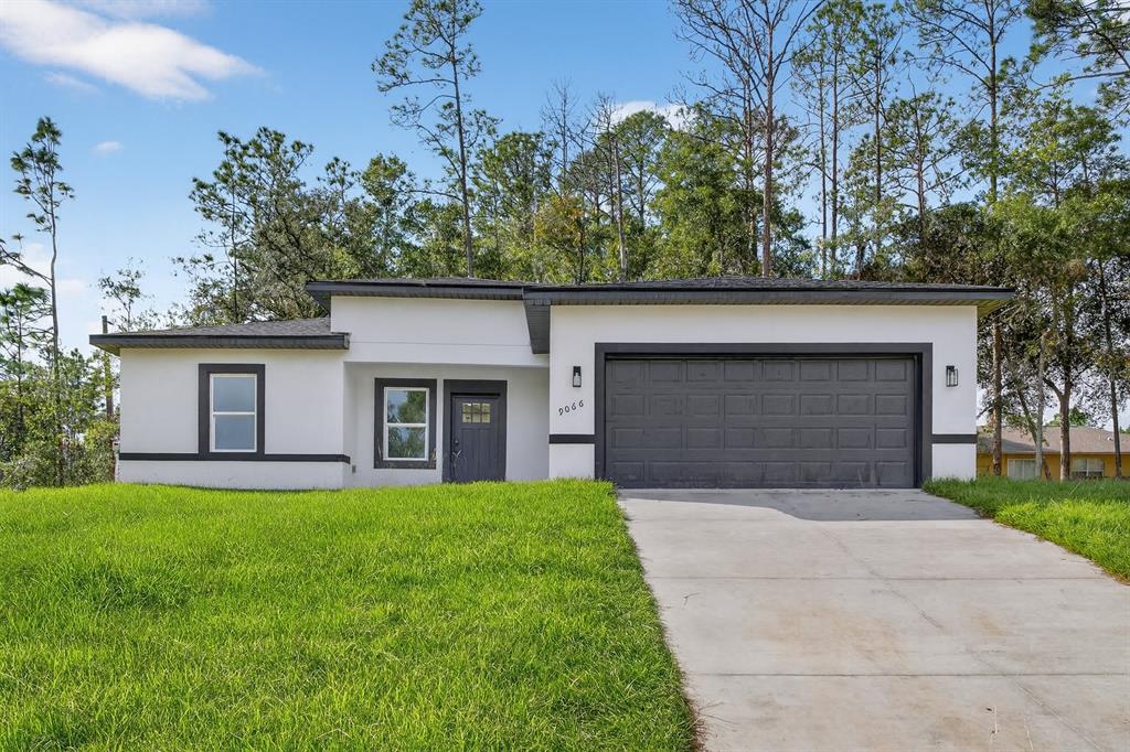 9066 North Akola Way Citrus Springs, FL 34434 - Photo 1 of 32 a front view of house with yard and trees