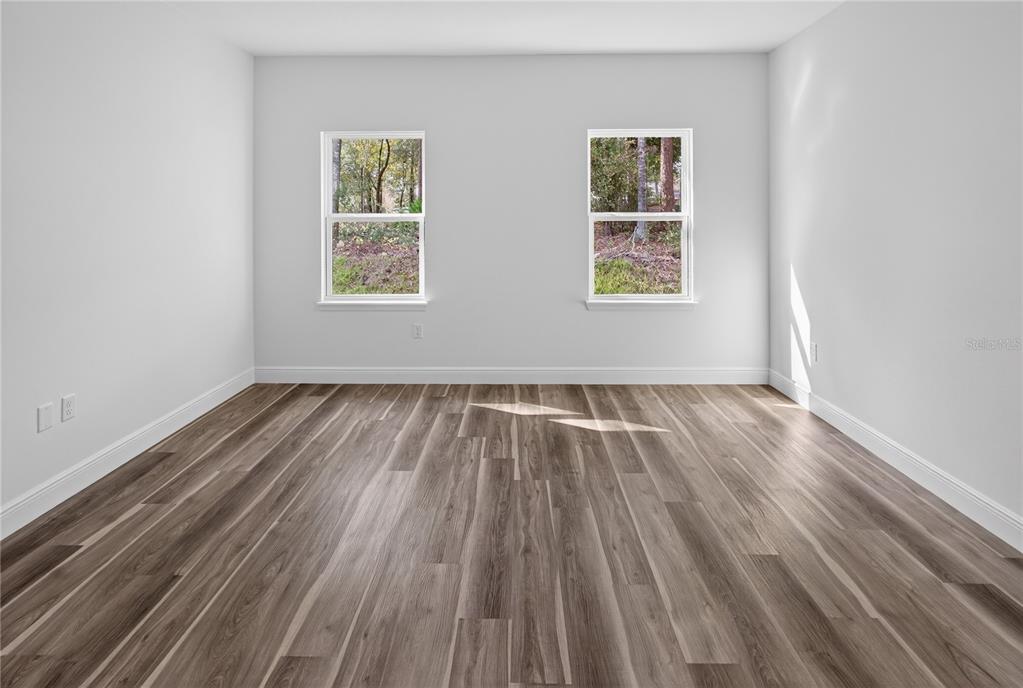 9066 North Akola Way Citrus Springs, FL 34434 - Photo 12 of 32 an empty room with wooden floor and windows