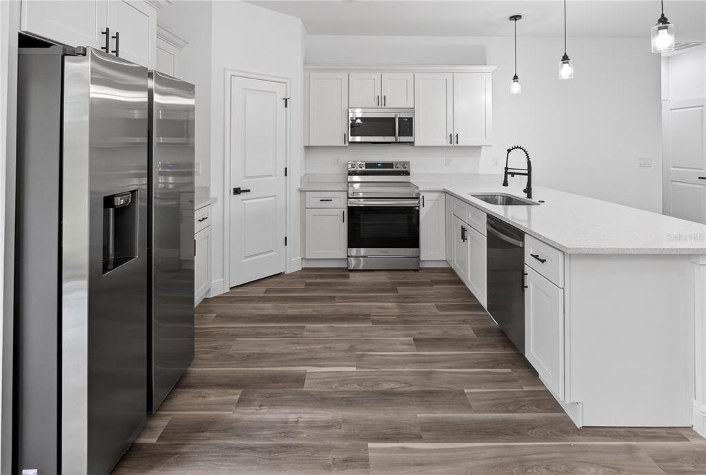 9066 North Akola Way Citrus Springs, FL 34434 - Photo 19 of 32 a kitchen with stainless steel appliances a refrigerator sink and white cabinets