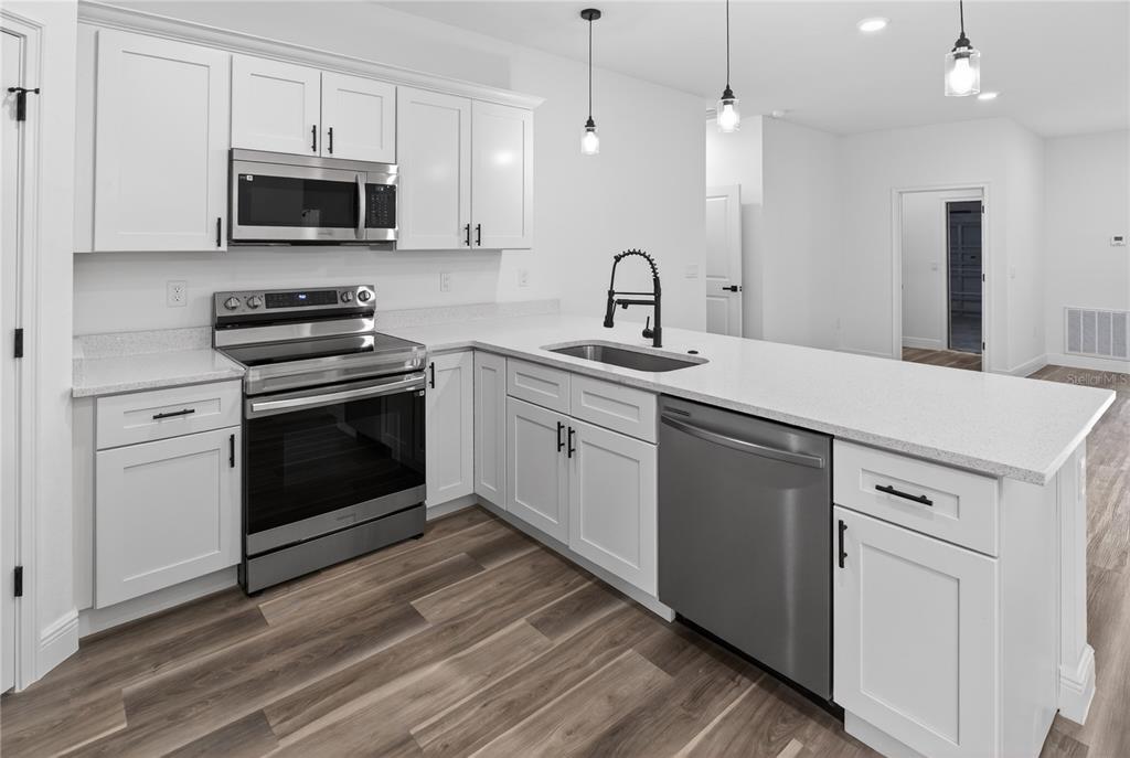 9066 North Akola Way Citrus Springs, FL 34434 - Photo 21 of 32 a kitchen with a sink stove and microwave