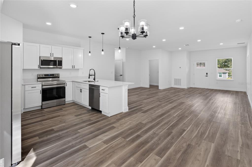 9066 North Akola Way Citrus Springs, FL 34434 - Photo 22 of 32 a large kitchen with cabinets wooden floor and stainless steel appliances