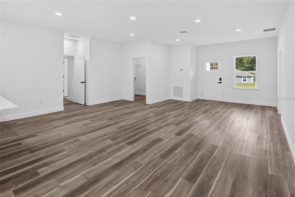 9066 North Akola Way Citrus Springs, FL 34434 - Photo 28 of 32 an empty room with wooden floor and windows