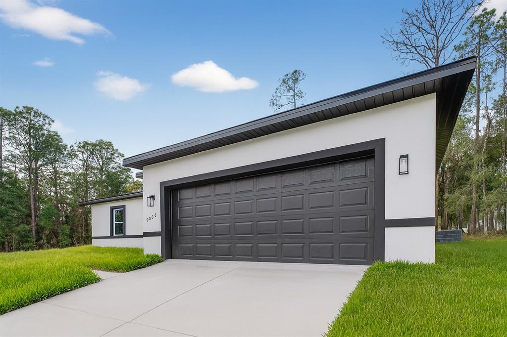 9066 North Akola Way Citrus Springs, FL 34434 - Photo 29 of 32 a front view of a house with a yard and garage