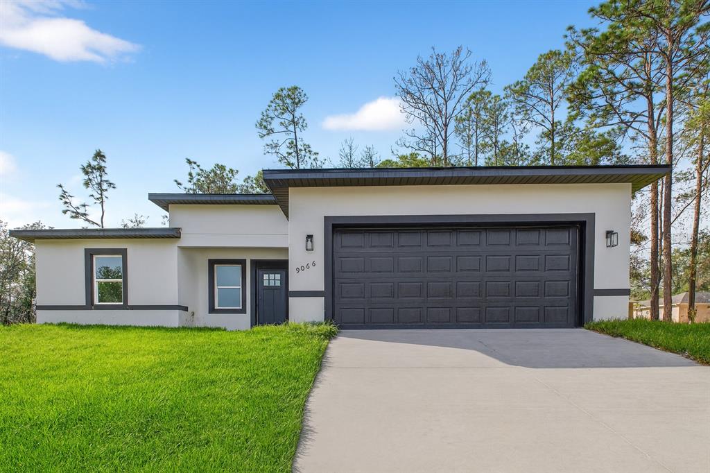 9066 North Akola Way Citrus Springs, FL 34434 - Photo 32 of 32 a front view of a house with a yard and garage