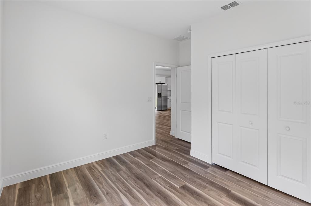9066 North Akola Way Citrus Springs, FL 34434 - Photo 6 of 32 a view of an empty room with wooden floor and closet