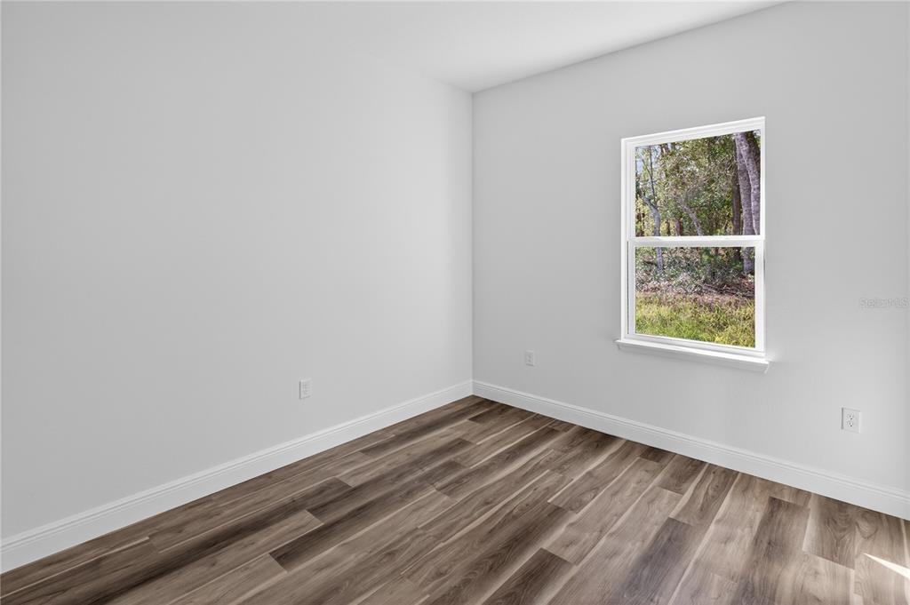 9066 North Akola Way Citrus Springs, FL 34434 - Photo 7 of 32 wooden floor in an empty room with a window