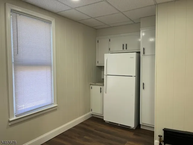 a view of a kitchen with wooden floor and a refrigerator